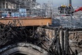 クレーンのつりかごから再建作業中の仏パリのノートルダム大聖堂の火災で焼けた木造部を見る作業員ら（2020年11月24日撮影）。(c) Martin BUREAU / AFP