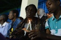 ルワンダの首都キガリ（Kigali）の競技場で行われたジェノサイド（大量虐殺）から20年の追悼式典で、ろうそくの火を受け渡す若者と女性（2014年4月7日撮影）。(c)AFP/SIMON MAINA