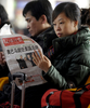 中国・北京（Beijing）で、バラク・オバマ（Barack Obama）米大統領の就任式について報じる新聞を読む女性（2009年1月21日撮影）。(c)AFP/LIU Jin
