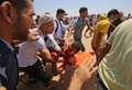 パレスチナ自治区ガザ地区のイスラエルとの境界付近で行われたデモで、搬送される負傷者（2018年6月8日撮影）。(c)AFP PHOTO / SAID KHATIB