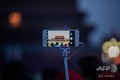 「新たな天安門」は不可能に、監視と弾圧を強める中国 中国・北京の天安門広場で、写真を撮るために掲げられたスマートフォン(2019年4月1日撮影)。(c)AFP