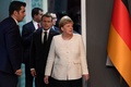 トルコのイスタンブールで、シリア情勢を話し合う4か国首脳会談後の共同記者会見会場に到着したドイツのアンゲラ・メルケル首相（右）とフランスのエマニュエル・マクロン大統領（中央、2018年10月27日撮影）。(c)Bertrand GUAY / AFP