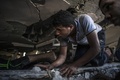 パレスチナ自治区ガザ地区（Gaza Strip）ガザ市（Gaza City）で、イスラエル軍の攻撃で破壊された建物のがれきの中で生存者を探すパレスチナ人男性（2014年8月4日撮影）。(c)AFP/MARCO LONGARI