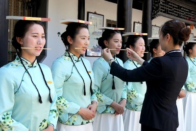 頭上に本、口に箸、手にはトランプ…中国観光ガイドのマナー講習