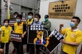 香港の警察署前で、中国の習近平国家主席を暗喩する「くまのプーさん」を描いたポスターを破る民主派の活動家ら（2020年5月24日撮影）。(c)AFP/ISAAC LAWRENCE