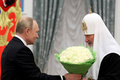 ロシア・モスクワで行われた式典で、ロシア正教会のキリル総主教（右）に花束を渡すウラジーミル・プーチン大統領（2021年11月20日撮影、資料写真）。(c)Mikhail Metzel / SPUTNIK / AFP