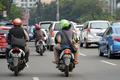 インドネシアのジャカルタで、乗客を運ぶ新興企業Go-Jekのバイクタクシー運転手（2015年6月11日撮影）。(c)AFP/ADEK BERRY