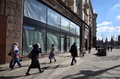 ロシア・モスクワ中心部の繁華街トベルスカヤ通りで、閉店した店舗の前を歩く人々（2022年3月16日撮影）。(c)AFP