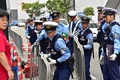 横浜市で開かれた安全保障関連法案に関する地方公聴会の会場周辺で、デモ参加者を食い止めるバリケードを設置する警官ら（2015年9月16日撮影）。(c)AFP/Yoshikazu TSUNO