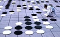 巨大囲碁を抱えながら局面を考えるちびっこ棋士（2018年11月12日撮影）。(c)CNS/王中挙