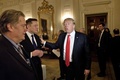 ドナルド・トランプ米大統領（中央）と、スティーブ・バノン元首席戦略官（左、2017年2月3日撮影、資料写真）。(c)Brendan Smialowski / AFP