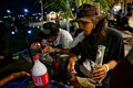 タイ中部ナコンパトム県で開催された大麻の合法化を祝うイベント「タイランド420: リーガルレーオ⁉」で、大麻を吸う人（2022年6月11日撮影）。(c)Lillian SUWANRUMPHA / AFP