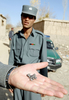 2007年11月24日、アフガニスタンの首都カブール（Kabul）西25キロにあるパグマン（Paghman）で、自爆攻撃の現場で見つかった軸受の残がいを示すアフガニスタン兵士。(c)AFP/MASSOUD Hossaini