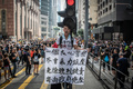 香港で行われた反政府デモで、警察の暴力を非難するメッセージが書かれた布を手にした参加者（2019年7月21日撮影）。(c)Laurel CHOR / AFP