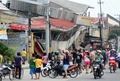 フィリピン・セブ（Cebu）市で、地震で倒壊した建物を見る人々（2013年10月15日撮影）。(c)AFP
