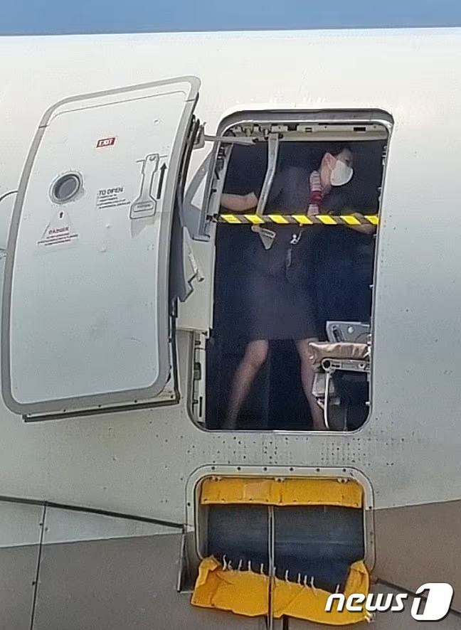 2023年5月26日、済州発大邱行きアシアナ航空機で30代男性乗客が着陸直前に非常口を強制的に開け、客室乗務員が必死に対応している＝読者提供(c)news1