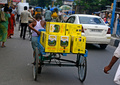 インド西ベンガル州シリグリの通りを、荷台にギーを乗せて運ぶ労働者（2015年9月8日撮影）。(c)AFP/Diptendu DUTTA
