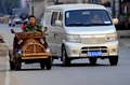 手作りの木製電気自動車で中国北東部の遼寧（Liaoning）省瀋陽（Shenyang）の道路を走る大工の劉福竜（Liu Fulong）さん（2014年10月29日撮影）。(c)AFP