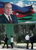 アゼルバイジャンの首都バクー（Baku）で、イルハム・アリエフ（Ilham Aliyev）現大統領の父、故ヘイダル・アリエフ（Heidar Aliyev）前大統領の広告板の下を歩く人々（2008年10月14日撮影）。(c)AFP/VANO SHLAMOV
