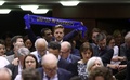 ベルギーの首都ブリュッセルにある欧州議会で行われたブレグジット協定案の採決で、「多様性の中で団結を」と書かれたスカーフを掲げる議員（2020年1月29日撮影）。(c)YVES HERMAN / POOL / AFP