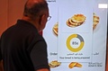 無料のパンを自動で提供する機械を利用する男性。アラブ首長国連邦（UAE）のドバイで（2022年9月22日撮影）。(c)Karim SAHIB / AFP