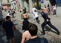 写真はウクライナ西部リビウ（Lviv）で通行人に水を浴びせた男性を逮捕しようと走る警察官（2013年5月6日撮影）。(c)AFP/YURIY DYACHYSHYN