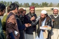 パキスタン北西部ペシャワールの難民キャンプで、アフガニスタンで「暴力削減措置期間」の合意がされたことを祝福しお菓子を配る難民（2020年2月22日撮影）。(c)Abdul MAJEED / AFP