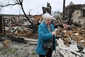 ウクライナ首都キーウ北西にある集落モシチュンで、破壊された自宅前で涙ぐむ住民（2022年4月20日撮影）。(c)Genya SAVILOV / AFP