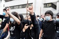 「覆面禁止規則」違反の罪で起訴されたデモ参加者2人が出廷した香港東区の裁判所でスローガンを叫ぶ民主派の活動家ら（2019年10月7日撮影）。(c)Mohd RASFAN / AFP