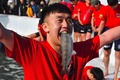 韓国・江原道の華川で開かれたヤマメ祭りのつかみ取りでヤマメをくわえる男性（2019年1月5日撮影）。(c)Jung Yeon-je / AFP