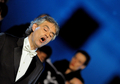イタリア・ローマ（Rome）の古代遺跡コロッセオ（Colosseum）で25日、オペラ歌手アンドレア・ボチェッリ（Andrea Bocelli）が同国アブルツォ（Abruzzo）州の交響楽団とともに、チャリティーコンサートを開催した。このコンサートは、4月のイタリア中部地震で被害を受けた音楽学校の再建を目的に行われた。会場に入ることのできた観客は、わずか380人だった。写真は、ステージで歌声を披露するボチェッリ（2009年5月25日撮影）。(c)AFP/TIZIANA FABI