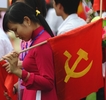ベトナム・ハノイ（Hanoi）で行われた軍事パレードを終え、旗と手に会場を後にする少女（2010年10月10日撮影）。(c)AFP/HOANG DINH Nam