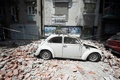 メキシコの首都メキシコ市で、地震により損壊した建物のがれきを受け損傷した車（2017年9月19日撮影）。(c)AFP/Alfredo ESTRELLA