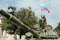 グルジア・南オセチア自治州のツヒンバリ（Tskhinvali）で、ロシア国旗を戦車に立てるロシア軍兵士（2008年8月11日撮影）。(c)AFP/ANDREI SMIRNOV