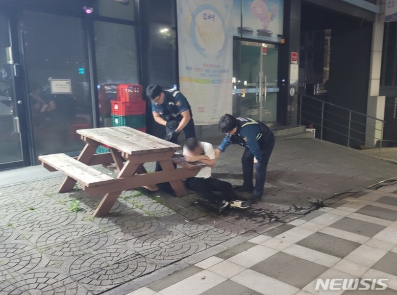 済州の歩道で寝ている泥酔者に措置を取る警察官＝写真は記事の内容とは関係ありません(c)NEWSIS