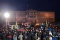 ギリシャの首都アテネの国会議事堂にトラクターや車で到着した、年金改革などに抗議する農業従事者たちに声援を送る支持者たち（2016年2月12日撮影）。(c)AFP/LOUISA GOULIAMAKI