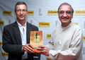 写真は同著を手にポーズをとるJohn Zubrzycki（左）とインド人作家の%%Narender Luthar%%。(c)AFP/NOAH SEELAM