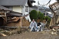 台風19号（アジア名：ハギビス）の影響を受けた長野県で、洪水の被害に見舞われた住宅の脇を歩く住民ら（2019年10月15日撮影）。(c)Kazuhiro NOGI / AFP
