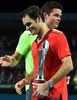 テニス、ブリスベーン国際（Brisbane International 2015）男子シングルス決勝。優勝トロフィーを手にするロジャー・フェデラー（Roger Federer、手前）とそれを称えるミロス・ラオニッチ（Milos Raonic、2015年1月11日撮影）。(c)AFP/Saeed KHAN