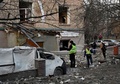 ウクライナの首都キーウで、ロシアの攻撃で損壊した住宅を現場検証する警察官（2022年12月31日撮影）。(c)SERGEI CHUZAVKOV / AFP