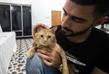 イラク南部の都市バスラにオープンした国内初の猫専用ホテルで、猫の世話をする獣医学生のアフマド・ターヘルさん（2018年3月28日撮影）。(c)AFP PHOTO / HAIDAR MOHAMMED ALI
