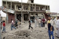 2008年4月10日、バグダッド（Baghdad）東部のサドルシティー（Sadr City）で、米軍の空爆で破壊された建物の周りに集まる人びと。(c)AFP/AHMAD AL RUBAYE