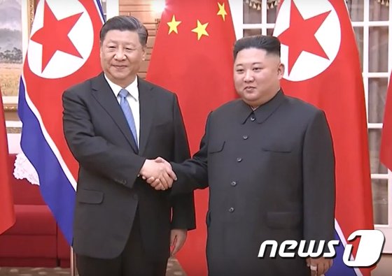 2019年6月20日、握手をする中国の習近平国家主席と北朝鮮の金正恩総書記（中国中央テレビの画面より）(c)news1