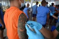 タイのチョンブリ中央刑務所で新型コロナウイルスのワクチン接種を受ける受刑者（2021年6月25日撮影）。(c)Lillian SUWANRUMPHA / AFP