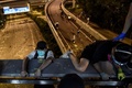 香港理工大学の構内から脱出するため、歩道橋から幹線道路へとロープで下りるデモ参加者（2019年11月18日撮影）。(c)AFP/Ye Aung Thu