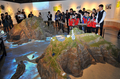 韓国・ソウル（Seoul）にオープンした「独島体験館（Dokdo Museum Seoul）」の開館式で、子供たちの間に立って竹島（Takeshima、韓国名・独島、Dokdo）のミニチュア展示を指差す歌手のキム・ジャンフン（Kim Jang-Hoon）氏（2012年9月14日撮影）。(c)AFP/JUNG YEON-JE