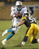 スティーラーズのジェームズ・ファリアー（%%James Farrior%%）のタックルをかわしにかかるドルフィンズのテッド・ギンJr（%%Ted Ginn Jr%%、左）。(c)AFP/Getty Images Gregory Shamus