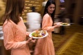 タイの首都バンコク郊外のアルメロスホテルで行われた結婚披露宴で、料理を盛った皿を手に歩く招待客たち（2017年1月15日撮影）。(c)AFP/Roberto SCHMIDT