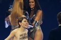 テレビ番組「Germany&apos;s next Topmodel」の決勝大会に乱入した女性権利団体「FEMEN」のメンバー。司会者のハイディ・クルム（Heidi Klum）さん（右）を中傷することばを、身体に英語で書きつけている（2013年5月30日撮影）。(c)AFP/ULI DECK