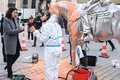 仏パリ中心部で、米国人芸術家チャールズ・レイ氏の彫刻「馬と騎手」にかけられたペンキを除去する作業員と話すリマ・アブデルマラク文化相（左、2022年11月18日撮影）。(c)Alain JOCARD / AFP